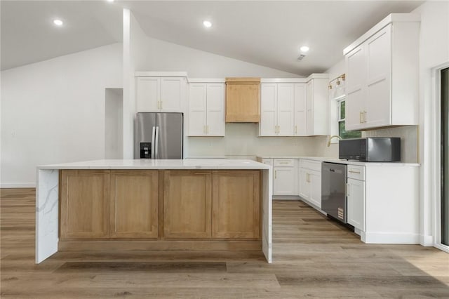 1348 Columbine Cv, Harrison, AR 72601 - kitchen featuring appliances with stainless steel finishes, vaulted ceiling, white cabinetry, a kitchen island, and light wood finished floors
