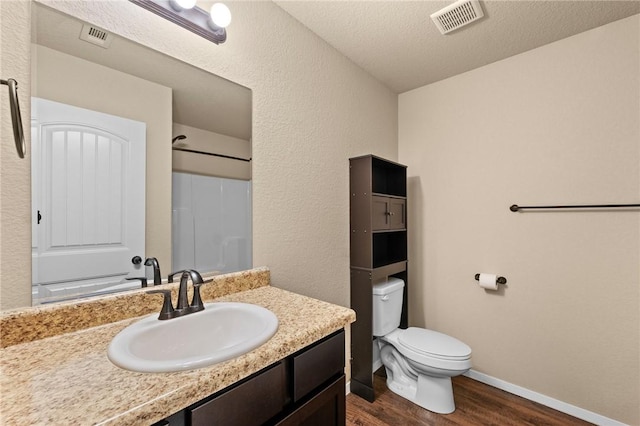 2504 Maplewood Ave, Lowell, AR 72745 - bathroom featuring wood finished floors, vanity, a shower, and a textured ceiling