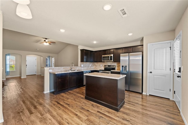 2504 Maplewood Ave, Lowell, AR 72745 - kitchen with appliances with stainless steel finishes, dark brown cabinets, arched walkways, tasteful backsplash, and ceiling fan