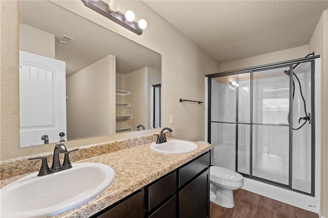 2504 Maplewood Ave, Lowell, AR 72745 - full bath featuring wood finished floors, a stall shower, double vanity, and a textured ceiling