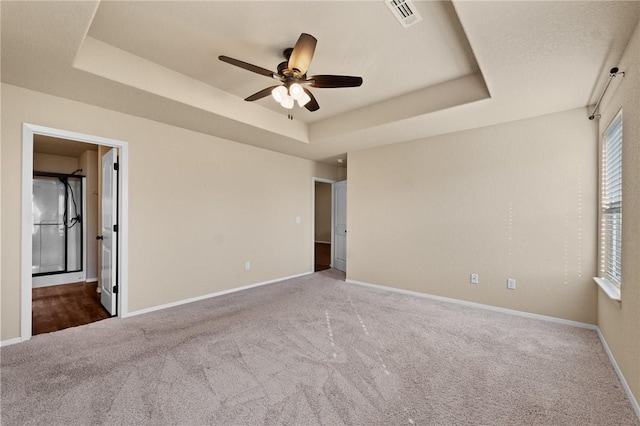 2504 Maplewood Ave, Lowell, AR 72745 - unfurnished bedroom with a tray ceiling, carpet, a ceiling fan, and ensuite bathroom