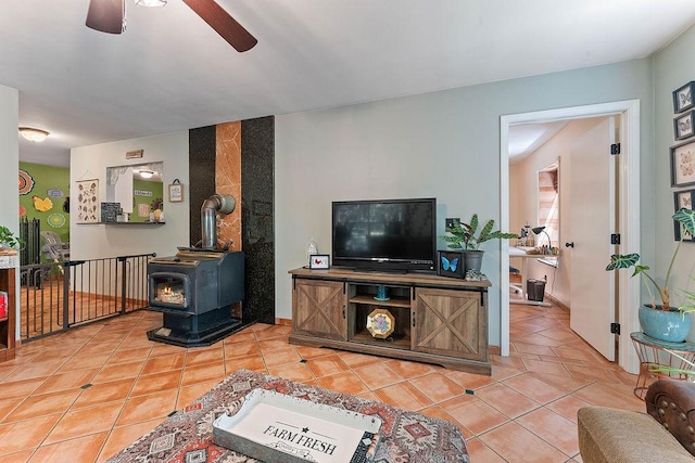 3389 Madison Unit 2405, Huntsville, AR 72740 - living area with light tile patterned flooring, a ceiling fan, and a wood stove