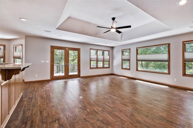 1 May Ln, Bella Vista, AR 72715 - unfurnished living room with a tray ceiling, dark wood-style flooring, ceiling fan, and recessed lighting