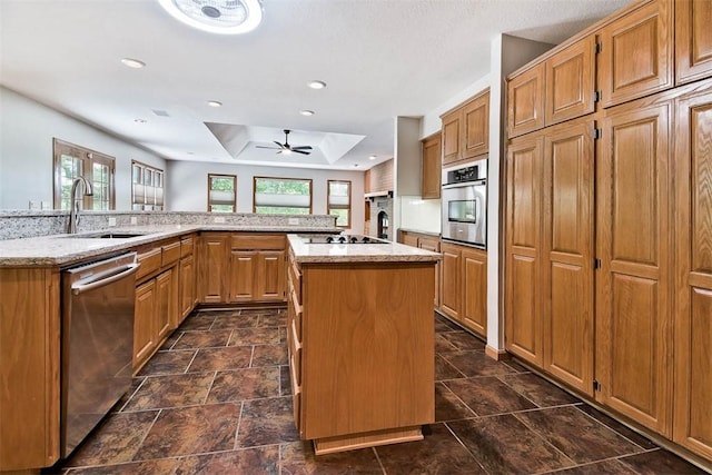 1 May Ln, Bella Vista, AR 72715 - kitchen with stainless steel appliances, a tray ceiling, a spacious island, light stone counters, and a ceiling fan