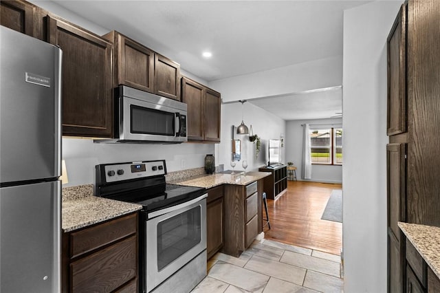 1115-1117 S Ellis Ave, Fayetteville, AR 72701 - kitchen featuring stainless steel appliances, dark brown cabinets, light stone countertops, and recessed lighting