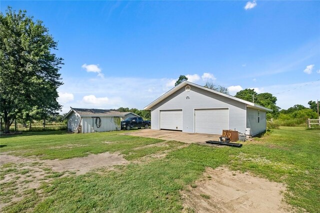 13183 Shady Grove Rd, Gravette, AR 72736 - view of green lawn featuring an outdoor structure and a detached garage