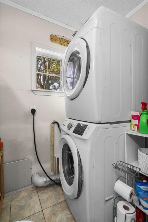 13183 Shady Grove Rd, Gravette, AR 72736 - laundry room with stacked washing machine and dryer, tile patterned flooring, a textured ceiling, and crown molding