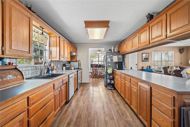 13183 Shady Grove Rd, Gravette, AR 72736 - kitchen with stainless steel appliances, light wood-style flooring, decorative backsplash, ceiling fan, and light countertops