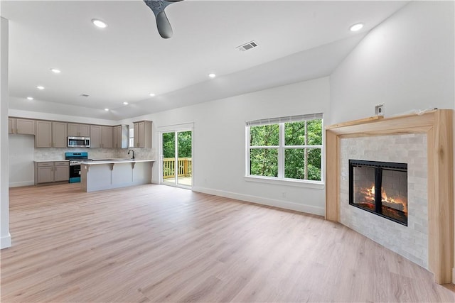 17 Westmorland Dr, Bella Vista, AR 72714 - unfurnished living room featuring light wood-style floors, a glass covered fireplace, and recessed lighting