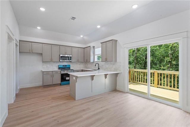 17 Westmorland Dr, Bella Vista, AR 72714 - kitchen featuring stainless steel appliances, gray cabinetry, a peninsula, light wood-style flooring, and tasteful backsplash