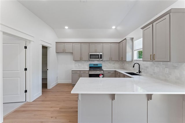 17 Westmorland Dr, Bella Vista, AR 72714 - kitchen with appliances with stainless steel finishes, gray cabinetry, a peninsula, light wood-style floors, and decorative backsplash