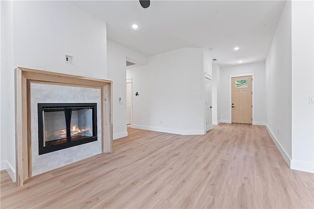 127 Overton Dr, Bella Vista, AR 72714 - unfurnished living room featuring light wood-type flooring, a glass covered fireplace, and recessed lighting