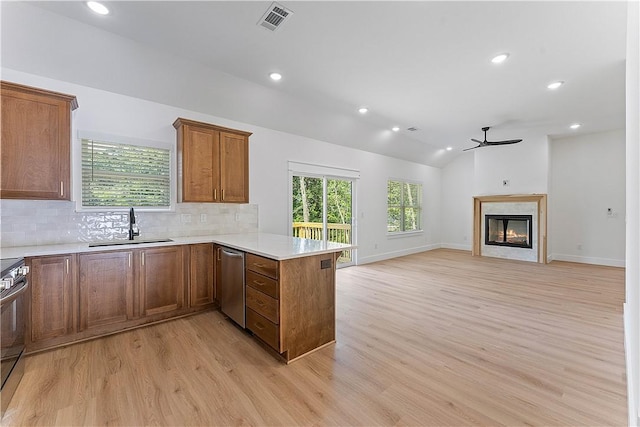 127 Overton Dr, Bella Vista, AR 72714 - kitchen with appliances with stainless steel finishes, a peninsula, a ceiling fan, light wood-type flooring, and backsplash