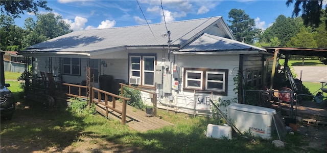 204 Glade St, Marshall, AR 72650 - back of property featuring cooling unit, a metal roof, and oil tank