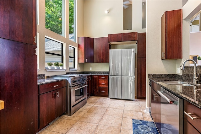 2855 E Hyland Park Rd, Fayetteville, AR 72701 - kitchen with appliances with stainless steel finishes, dark stone countertops, light tile patterned flooring, ceiling fan, and dark brown cabinets