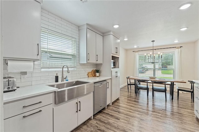 2905 NE 12th St, Bentonville, AR 72712 - kitchen with stainless steel dishwasher, decorative backsplash, light wood-type flooring, white cabinets, and recessed lighting