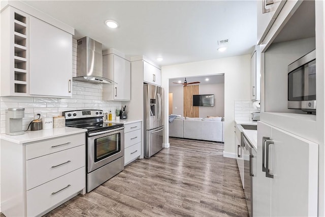 2905 NE 12th St, Bentonville, AR 72712 - kitchen featuring appliances with stainless steel finishes, wall chimney range hood, tasteful backsplash, light countertops, and recessed lighting