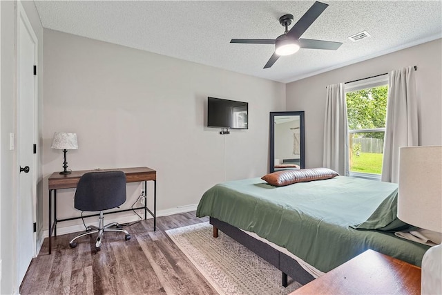 2905 NE 12th St, Bentonville, AR 72712 - bedroom featuring wood finished floors, a textured ceiling, an office area, and a ceiling fan
