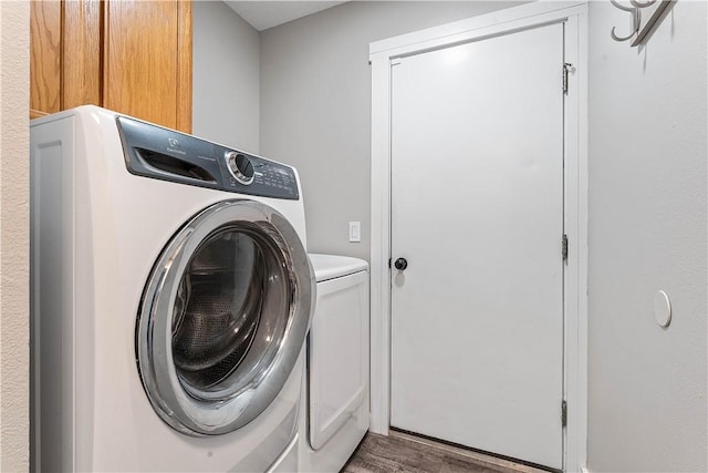 2905 NE 12th St, Bentonville, AR 72712 - laundry area with washer and dryer, wood finished floors, and cabinet space