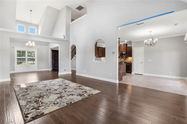 3915 Baltic St, Springdale, AR 72762 - living area featuring a chandelier, light wood finished floors, stairs, and a towering ceiling