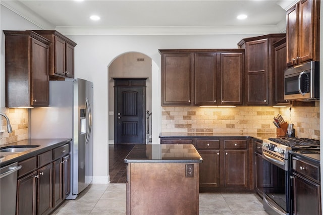 3915 Baltic St, Springdale, AR 72762 - kitchen featuring stainless steel appliances, a center island, arched walkways, backsplash, and crown molding