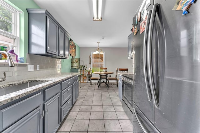2317 SW Morris St, Bentonville, AR 72712 - kitchen with appliances with stainless steel finishes, gray cabinets, decorative backsplash, and light tile patterned floors
