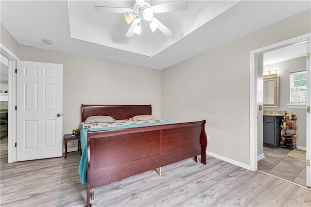 2317 SW Morris St, Bentonville, AR 72712 - bedroom featuring a raised ceiling, wood finished floors, ceiling fan, and ensuite bathroom