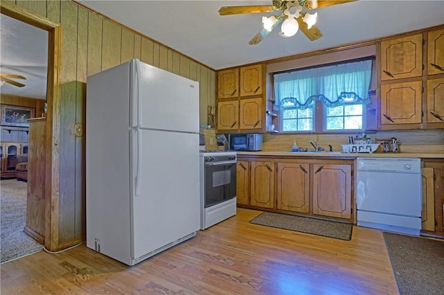 10746 Sr 27, Hector, AR 72843 - kitchen featuring white appliances, ceiling fan, brown cabinetry, light wood-style floors, and wood walls