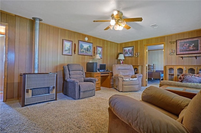 10746 Sr 27, Hector, AR 72843 - carpeted living room featuring a wood stove, ceiling fan, and wooden walls