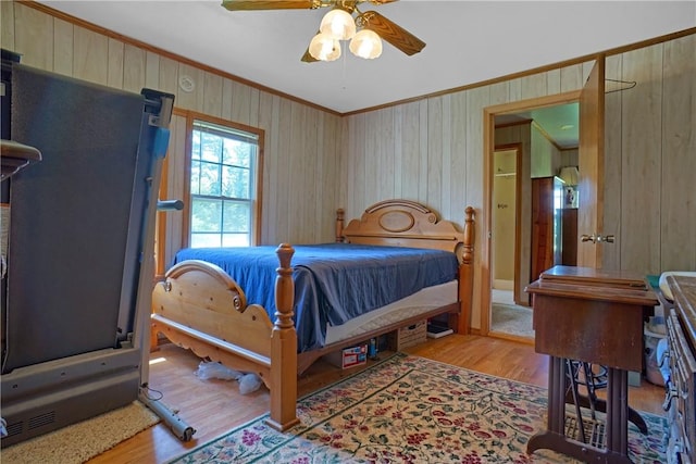 10746 Sr 27, Hector, AR 72843 - bedroom featuring ornamental molding, wood finished floors, wooden walls, and a ceiling fan