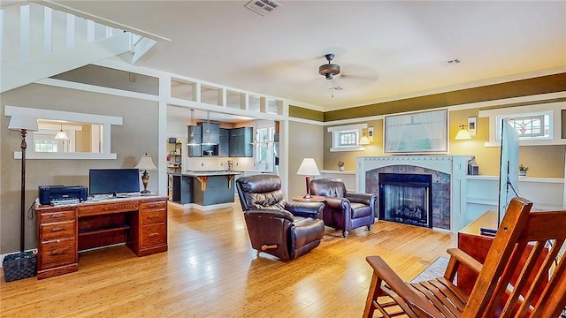 214 Lake Francis Dr, Siloam Springs, AR 72761 - living area featuring light wood-type flooring, a ceiling fan, a tiled fireplace, and an office area