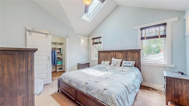 214 Lake Francis Dr, Siloam Springs, AR 72761 - bedroom with light carpet, vaulted ceiling, a skylight, a spacious closet, and a barn door