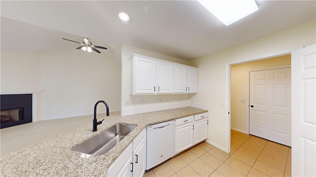 1142 S Jasmine Ln, Fayetteville, AR 72704 - kitchen with white dishwasher, white cabinets, ceiling fan, light stone countertops, and a fireplace