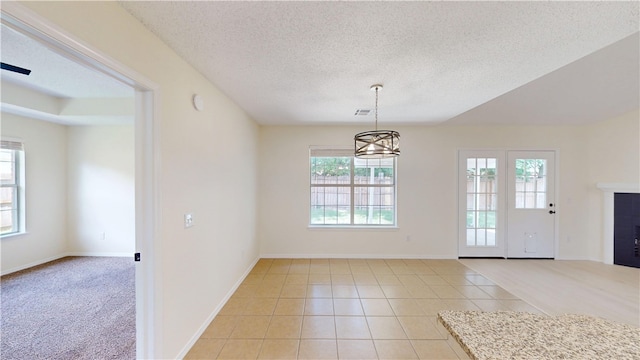 1142 S Jasmine Ln, Fayetteville, AR 72704 - unfurnished dining area featuring a textured ceiling, a tiled fireplace, a chandelier, and light tile patterned flooring