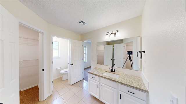 1142 S Jasmine Ln, Fayetteville, AR 72704 - full bath featuring vanity, a textured ceiling, tile patterned flooring, and a spacious closet