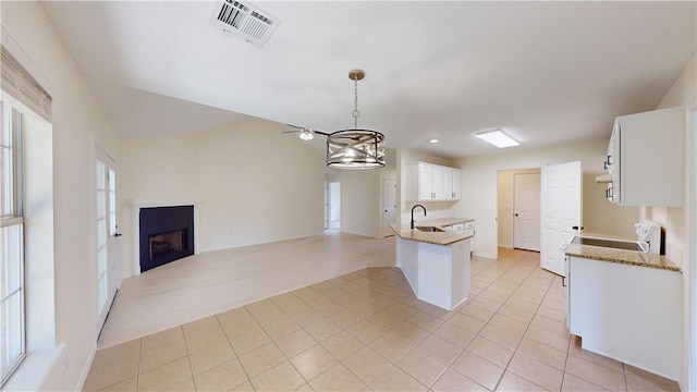 1142 S Jasmine Ln, Fayetteville, AR 72704 - kitchen featuring open floor plan, light tile patterned flooring, white cabinetry, and a fireplace