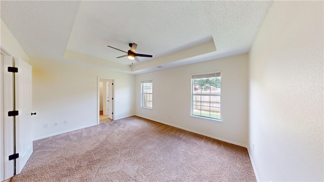 1142 S Jasmine Ln, Fayetteville, AR 72704 - spare room featuring a raised ceiling, light carpet, and a ceiling fan
