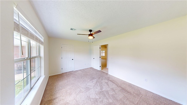 1142 S Jasmine Ln, Fayetteville, AR 72704 - unfurnished bedroom featuring light colored carpet, a textured ceiling, and a ceiling fan