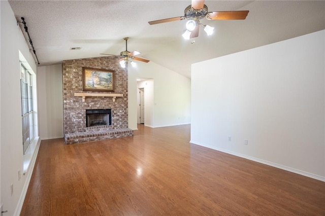 2472 W Jane Circle Dr, Fayetteville, AR 72704 - unfurnished living room with ceiling fan, vaulted ceiling, wood finished floors, and a brick fireplace