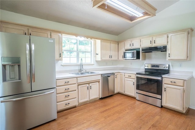 2472 W Jane Circle Dr, Fayetteville, AR 72704 - kitchen featuring appliances with stainless steel finishes, under cabinet range hood, vaulted ceiling, light countertops, and light wood-style flooring