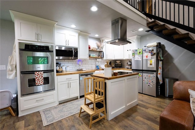 19475 Cotton Ln, Garfield, AR 72732 - kitchen featuring wood counters, appliances with stainless steel finishes, island exhaust hood, white cabinets, and recessed lighting