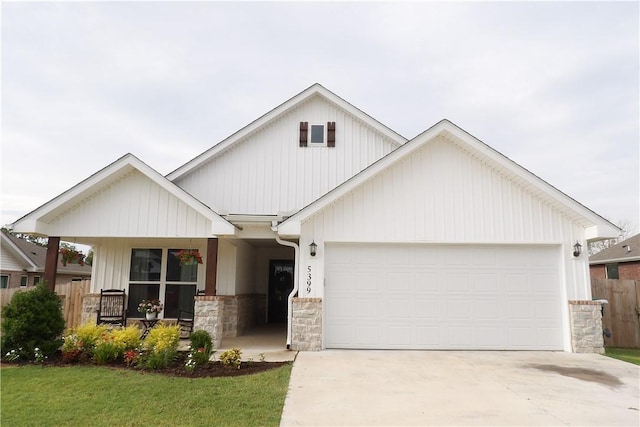 5399 Clear Springs Ave, Springdale, AR 72762 - view of front of house featuring concrete driveway, an attached garage, covered porch, stone siding, and a front yard