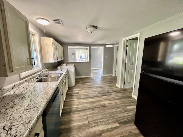 705 Commerce St, Morrilton, AR 72110 - kitchen featuring dishwasher, freestanding refrigerator, light countertops, dark wood finished floors, and washing machine and clothes dryer