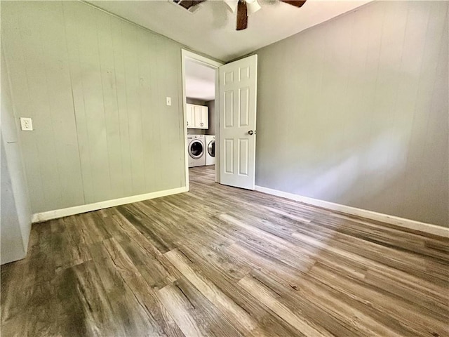 705 Commerce St, Morrilton, AR 72110 - spare room with washer and dryer, a ceiling fan, wood finished floors, and wooden walls