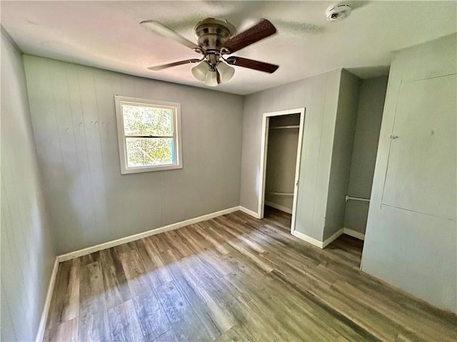 705 Commerce St, Morrilton, AR 72110 - unfurnished bedroom with wood finished floors, a ceiling fan, and a closet