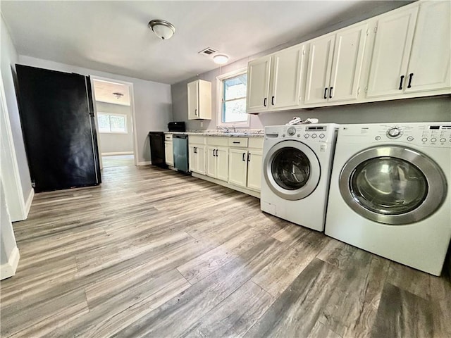 705 Commerce St, Morrilton, AR 72110 - laundry area featuring washer and dryer and light wood-type flooring