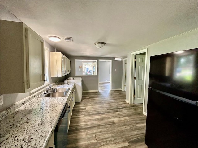 705 Commerce St, Morrilton, AR 72110 - kitchen with freestanding refrigerator, wood finished floors, dishwasher, and washing machine and clothes dryer