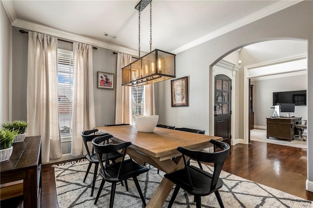 5503 S Turnberry Rd, Rogers, AR 72758 - dining room featuring arched walkways, dark wood-style flooring, crown molding, and a chandelier