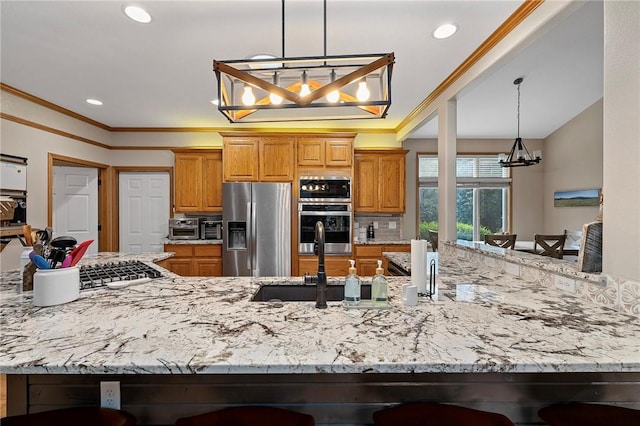 6 Leawood Pl, Bella Vista, AR 72715 - kitchen with appliances with stainless steel finishes, a chandelier, light stone counters, brown cabinetry, and crown molding