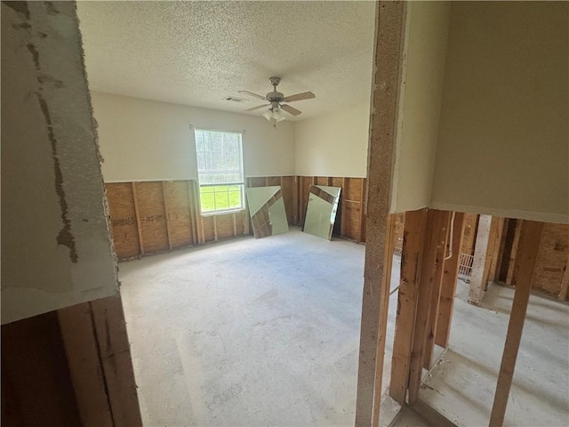 1811 Birchwood, Beebe, AR 72012 - empty room with ceiling fan, a textured ceiling, and a wainscoted wall